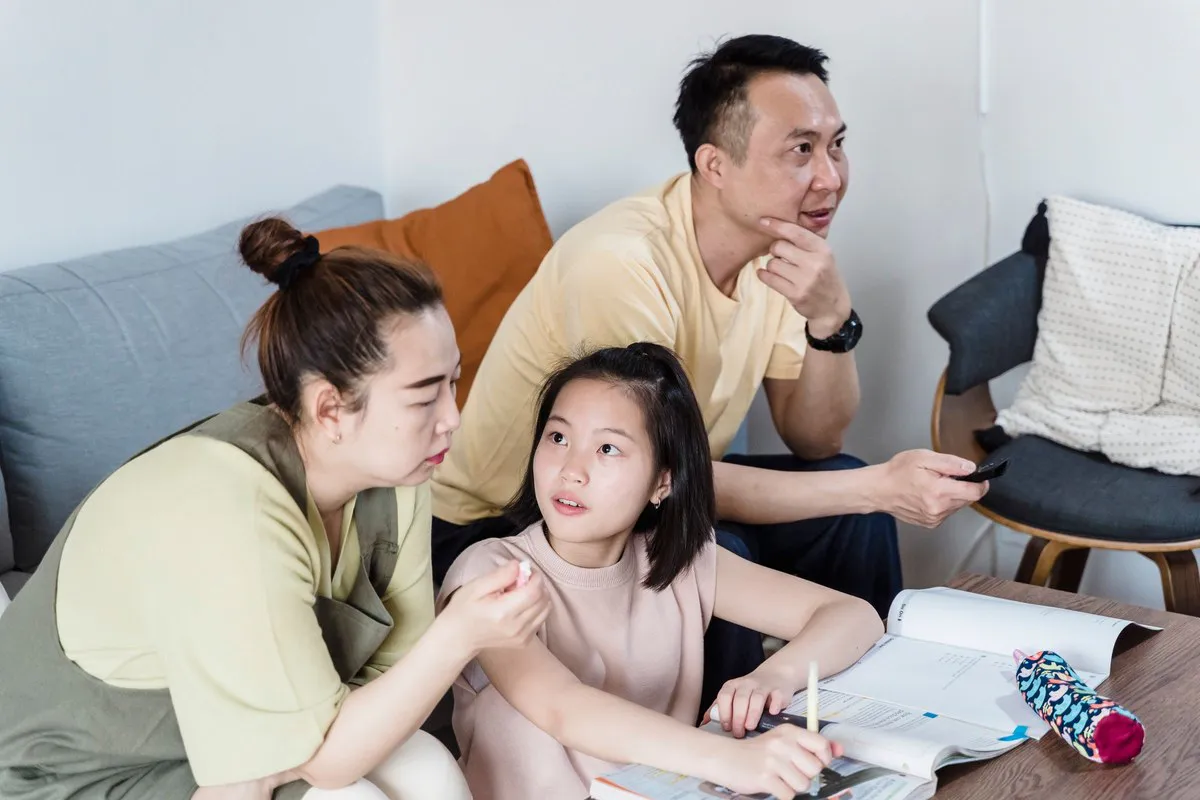 Parents helping their daughter with homework at home